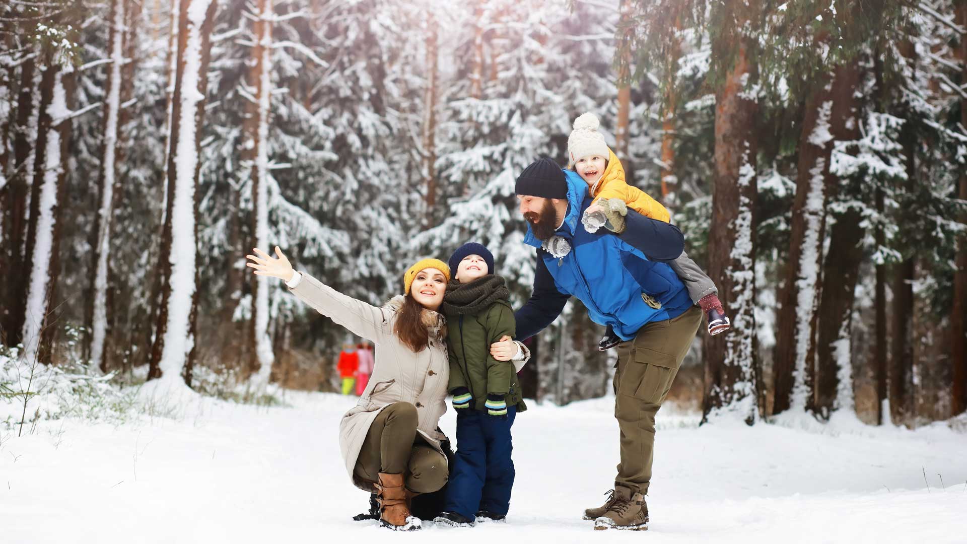 Happy family playing and laughing in winter outdoors in the snow.